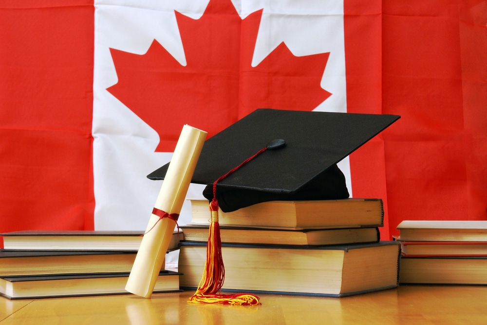 international student celebrating graduation while holding a Post-Graduation Work Permit in Canada, symbolizing new career opportunities